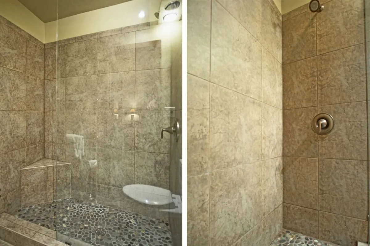 A modern bathroom with a glass-enclosed walk-in shower, pebble stone floor, and sleek fixtures. The space feels spa-like and rejuvenating, ideal for unwinding after a day of adventure.
